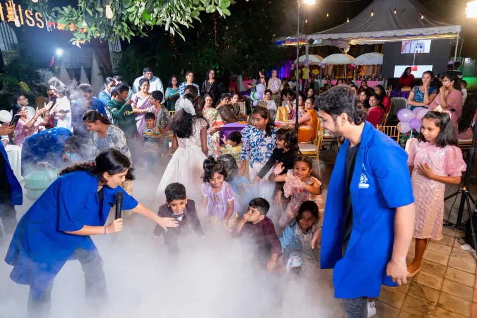 A garden party engulfed in white nitrogen fog, with children and parents standing in the cloud