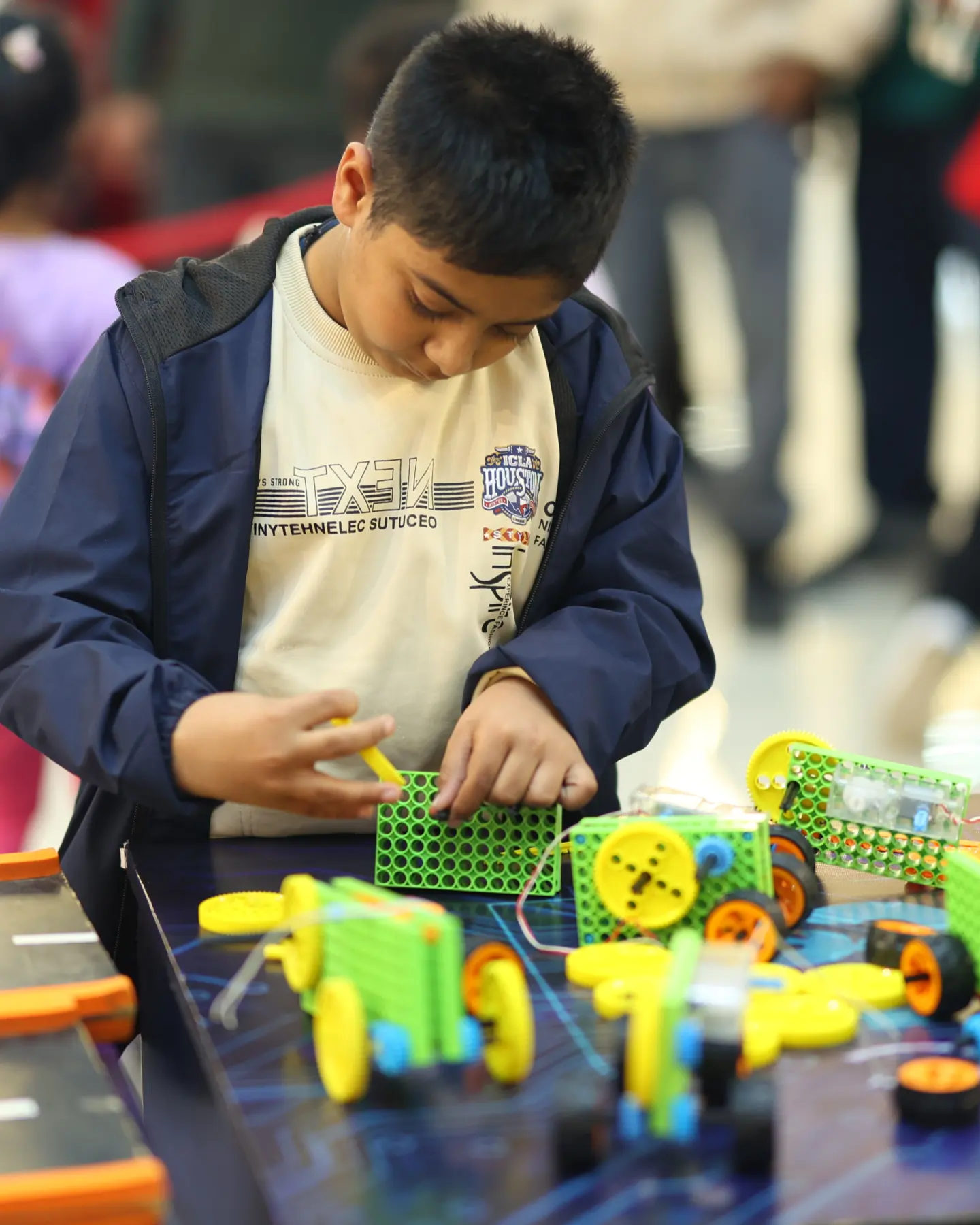 A boy concentrating as he assembles a motorised robotics kit at a MakerMasti science station