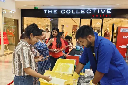A MakerMasti host running a hands-on activity for shoppers outside a mall store
