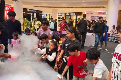 Dry ice fog rolling off a bowl as children crowd in to watch
