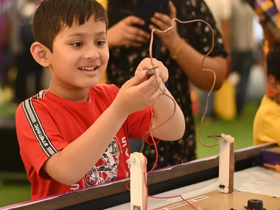 Children gathered around a MakerMasti science experiment at a birthday party