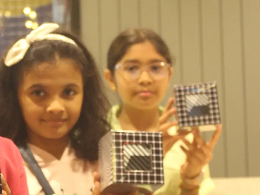 A birthday party group photo with the MakerMasti hosts and science decor