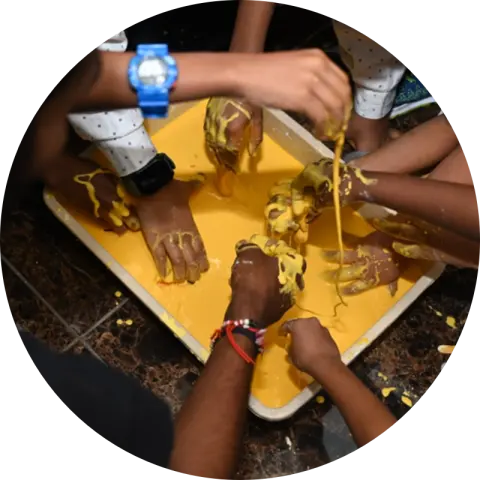 A child stretching brightly coloured slime between both hands